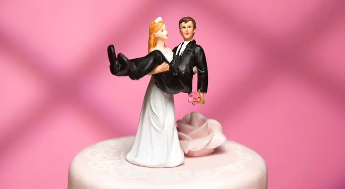 Wedding cake topper with bride holding the groom