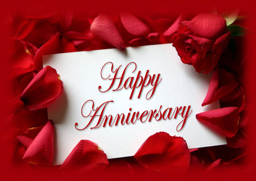 Happy Anniversary written on white card and surrounded by red flower petals for anniversary parties